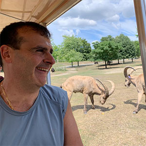 Man smiles as he rides the Zoo Mobile past some Tar at the Zoo